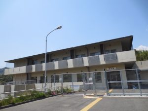 介護施設の建物外観。モダンデザインの2階建て、駐車場から撮影